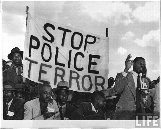 Protesters carrying banner reading STOP POLICE TERROR listen to speaker during a Communist meeting | South African History Online