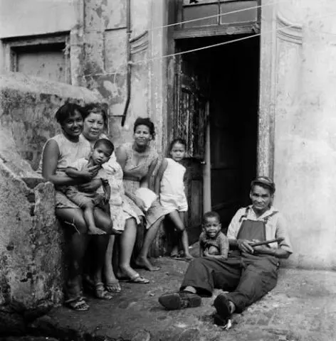 A family sits outside the front door of their District Six home 