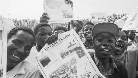 Children hold copies of the Freedom Charter aloft