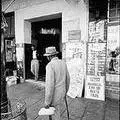 Man passing newspaper headline poster which reads: 'Mandela, Life or Death Trial'