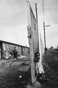 Child leaning on a fence