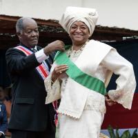 Ellen Johnson Sirleaf, dons the presidential sash with assistance from Liberia's Senior Ambassador-at-Large, George W. Wallace, Jr., during her inauguration ceremony at the Capitol Building in Monrovia, Liberia, January 16, 2006